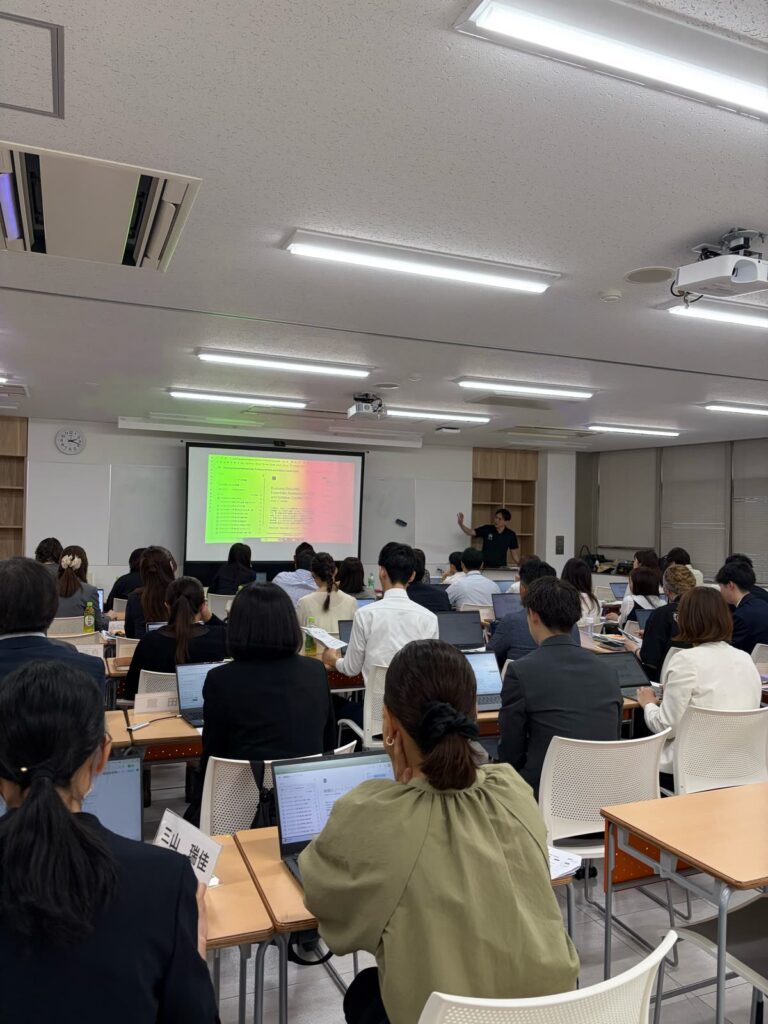 スクリーンの前で説明する講師と、ノートパソコンで実習に取り組む受講者の皆さま